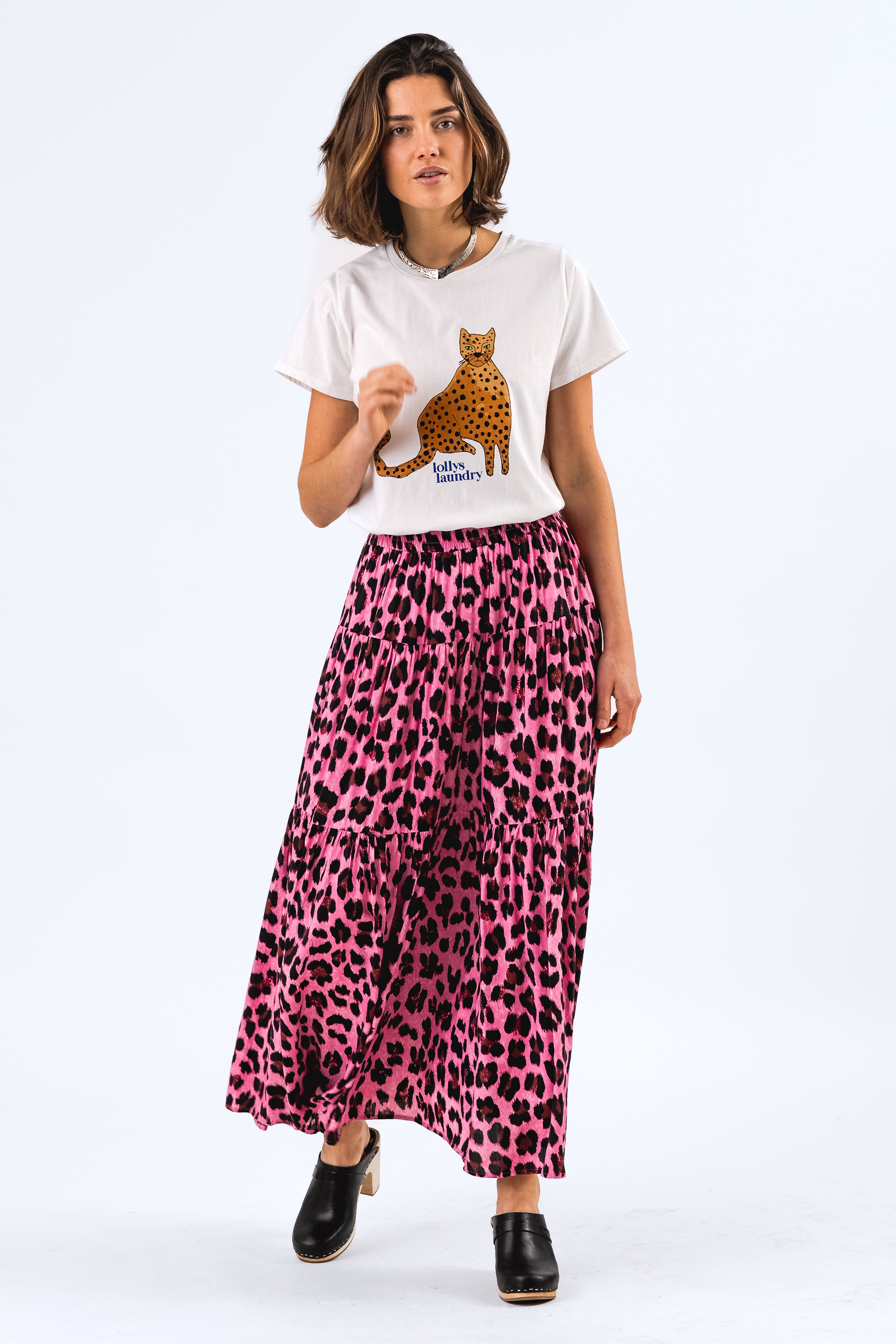 ROMA TEE Woman wearing a white t-shirt with a graphic design and a pink leopard print skirt on a white background