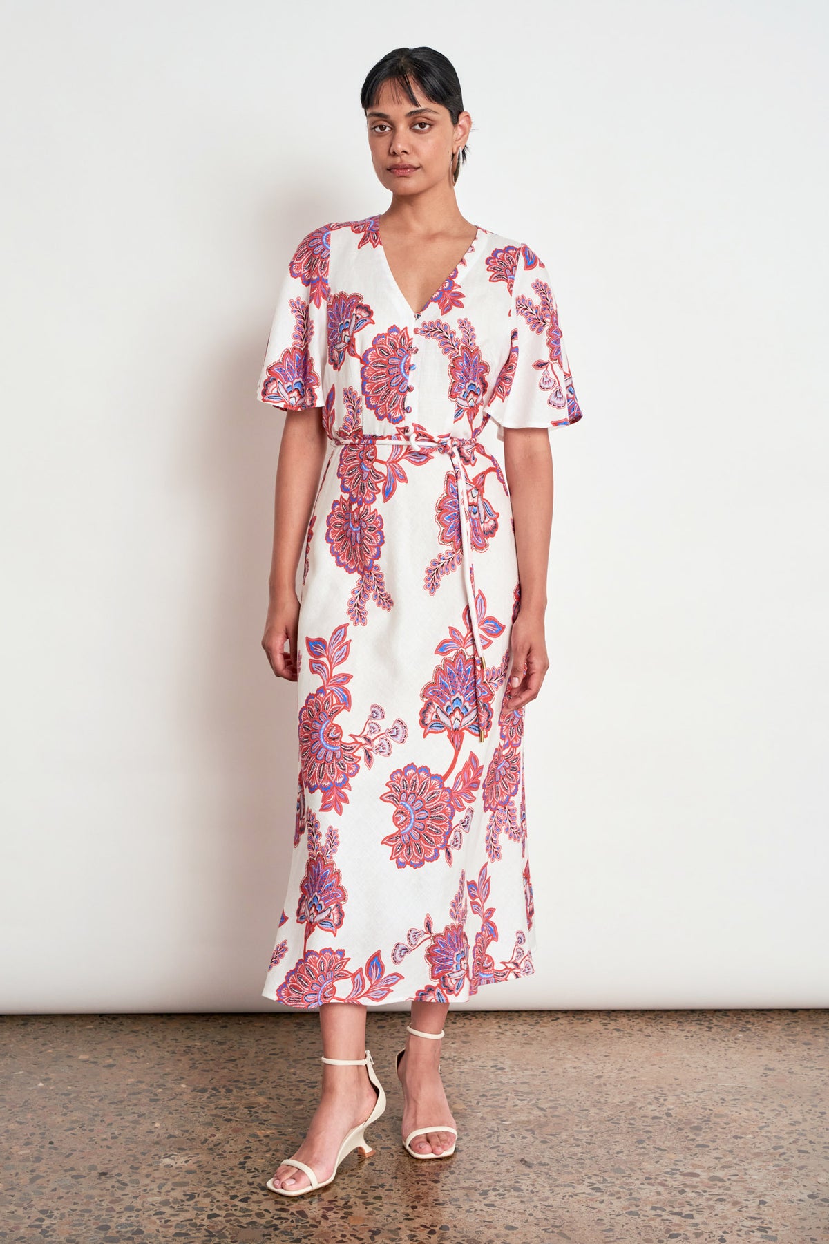 ZOE KRATZMANN PREMIER DRESS CRIMSON KGARI - A white midi dress with a vibrant pink and purple floral pattern.