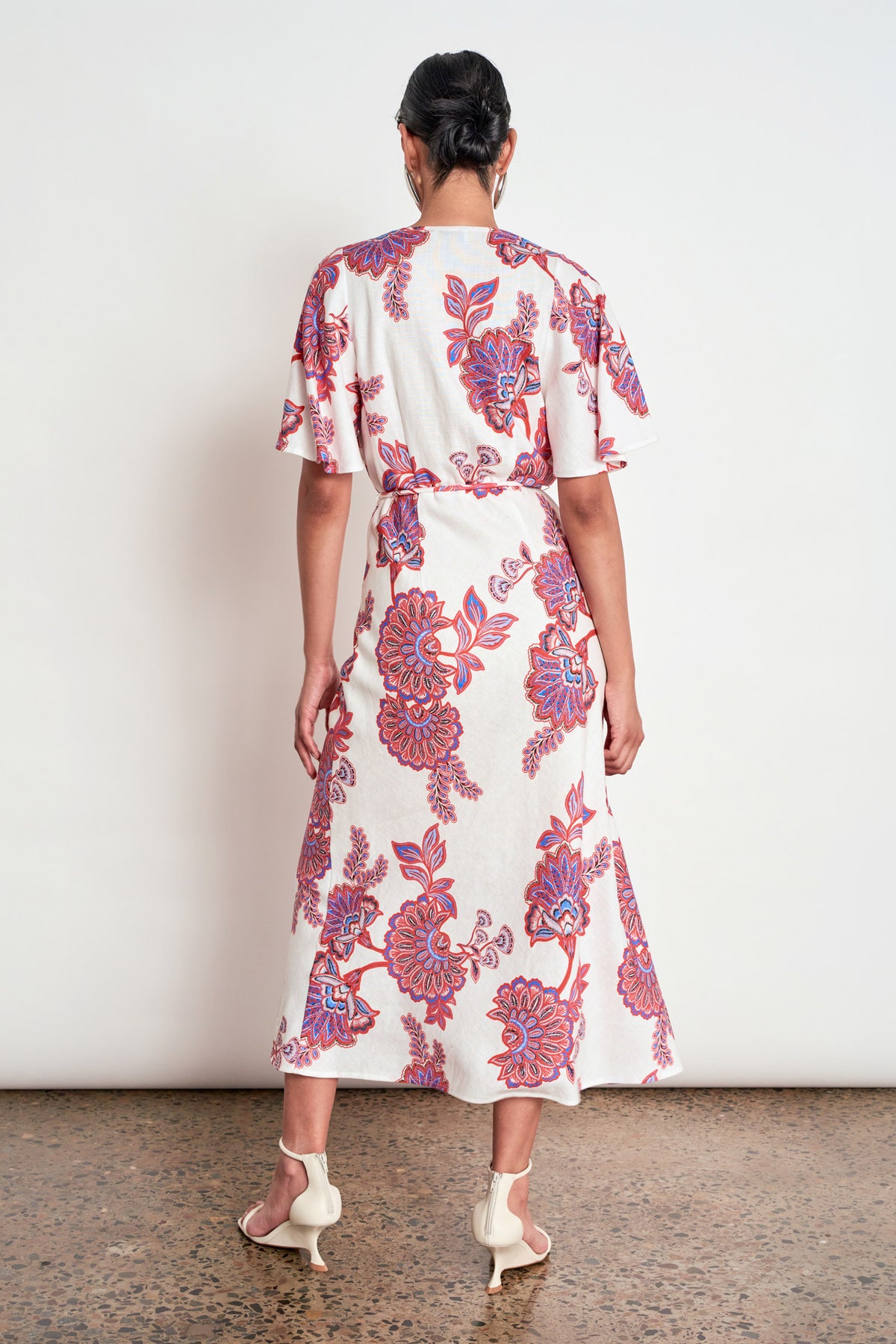 ZOE KRATZMANN PREMIER DRESS CRIMSON KGARI - A white midi dress with a vibrant pink and purple floral pattern.