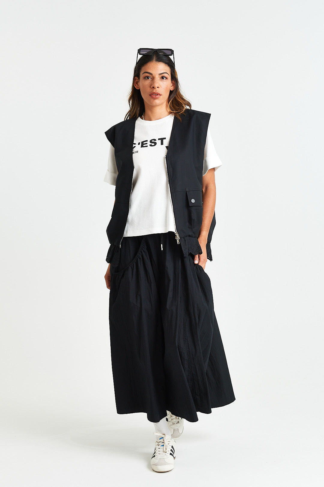 FRIDA TEE Person wearing a white t-shirt with text, black vest, and black pants on a white background