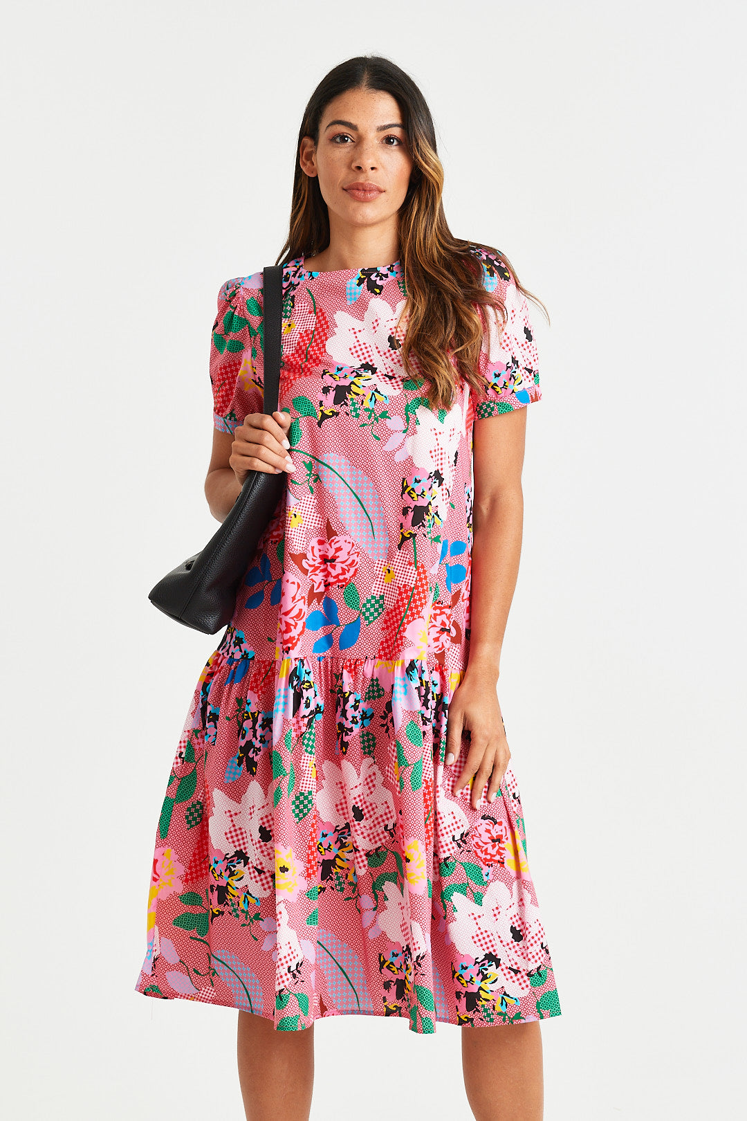 GASTON DRESS Woman wearing a colorful floral dress on a white background