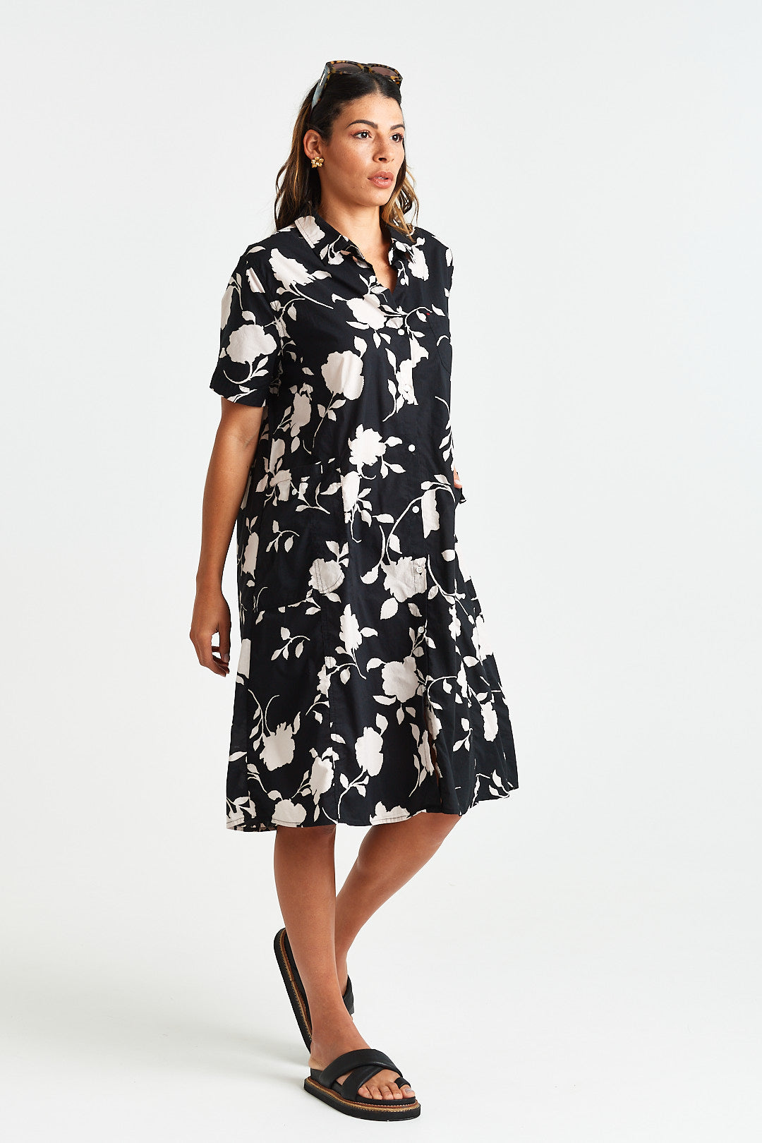 NOE DRESS Woman wearing a black floral dress on a white background