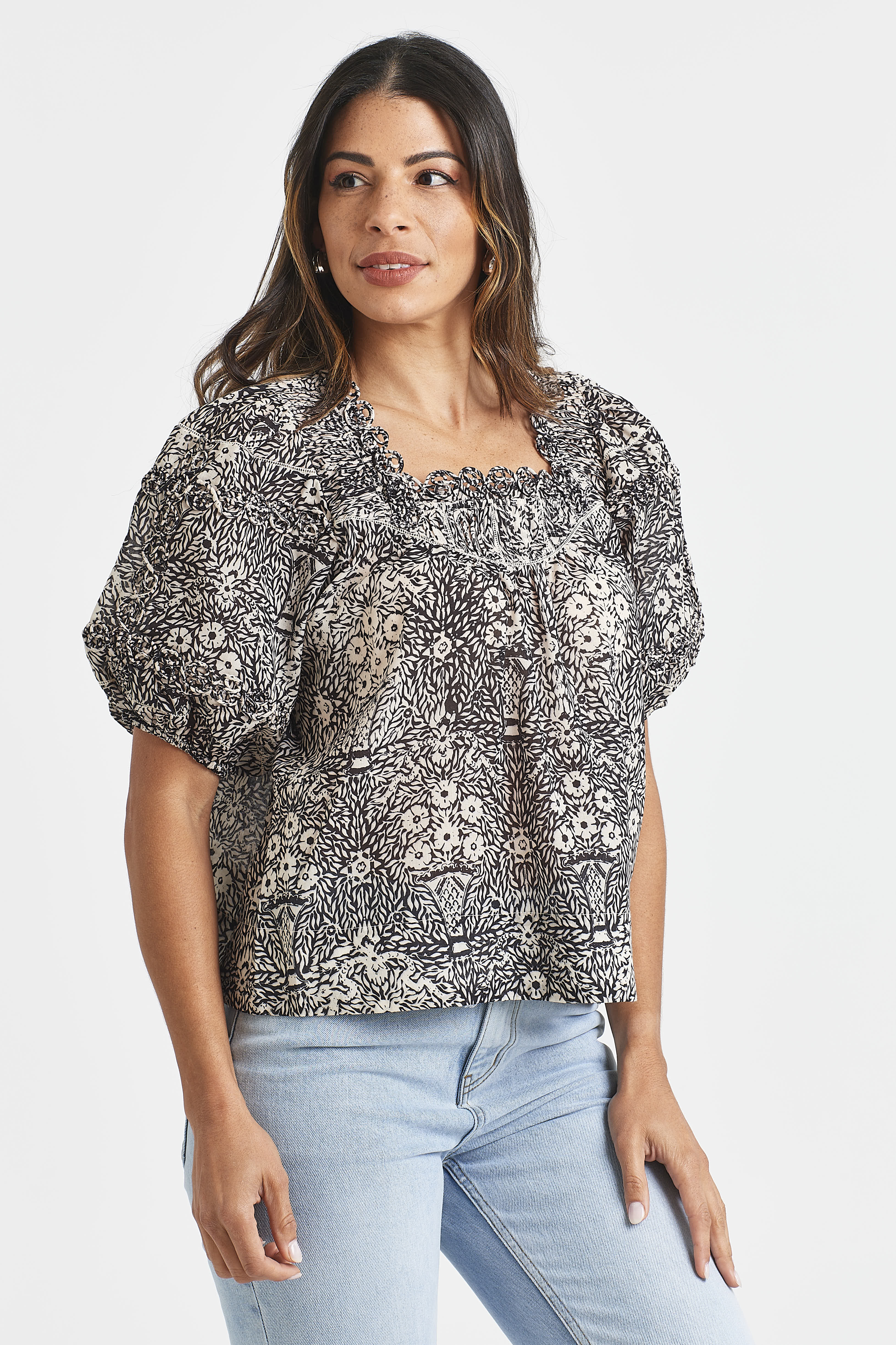 ALAIN TOP Woman wearing a floral blouse with puff sleeves on a white background