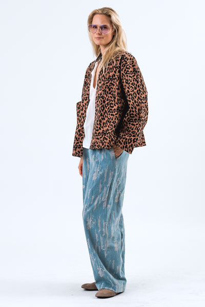 RUMI JACKET Person wearing a leopard print jacket and blue tie-dye pants on a white background