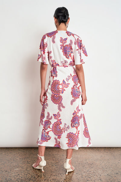 ZOE KRATZMANN PREMIER DRESS CRIMSON KGARI - A white midi dress with a vibrant pink and purple floral pattern.