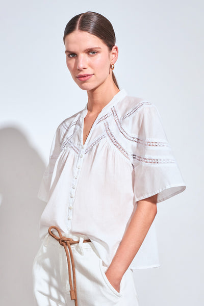 ZOE KRATZMANN PULSE TOP PORCELAIN - A white short-sleeve blouse with delicate eyelet embroidery across the chest and shoulders.