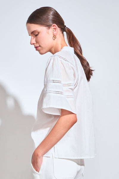 ZOE KRATZMANN PULSE TOP PORCELAIN - A white short-sleeve blouse with delicate eyelet embroidery across the chest and shoulders.