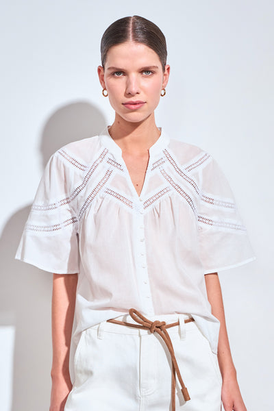 ZOE KRATZMANN PULSE TOP PORCELAIN - A white short-sleeve blouse with delicate eyelet embroidery across the chest and shoulders.