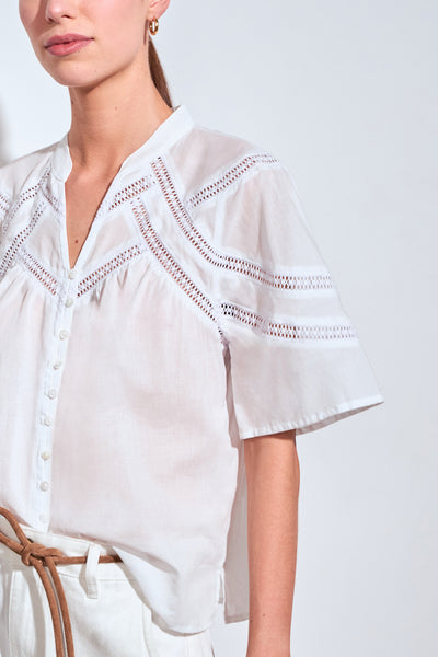 ZOE KRATZMANN PULSE TOP PORCELAIN - A white short-sleeve blouse with delicate eyelet embroidery across the chest and shoulders.