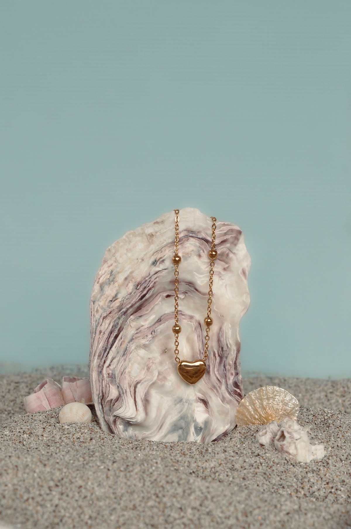 WENDYS DOT NECKLACE DELICATE GOLD CHAIN WITH SMALL GOLD BEADS SCATTERED ALONG THE CHAIN AND A SMALL GOLD HEART PENDANT