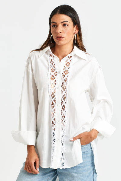 CLOVIS SHIRT Woman wearing a white blouse with lace detailing on a white background