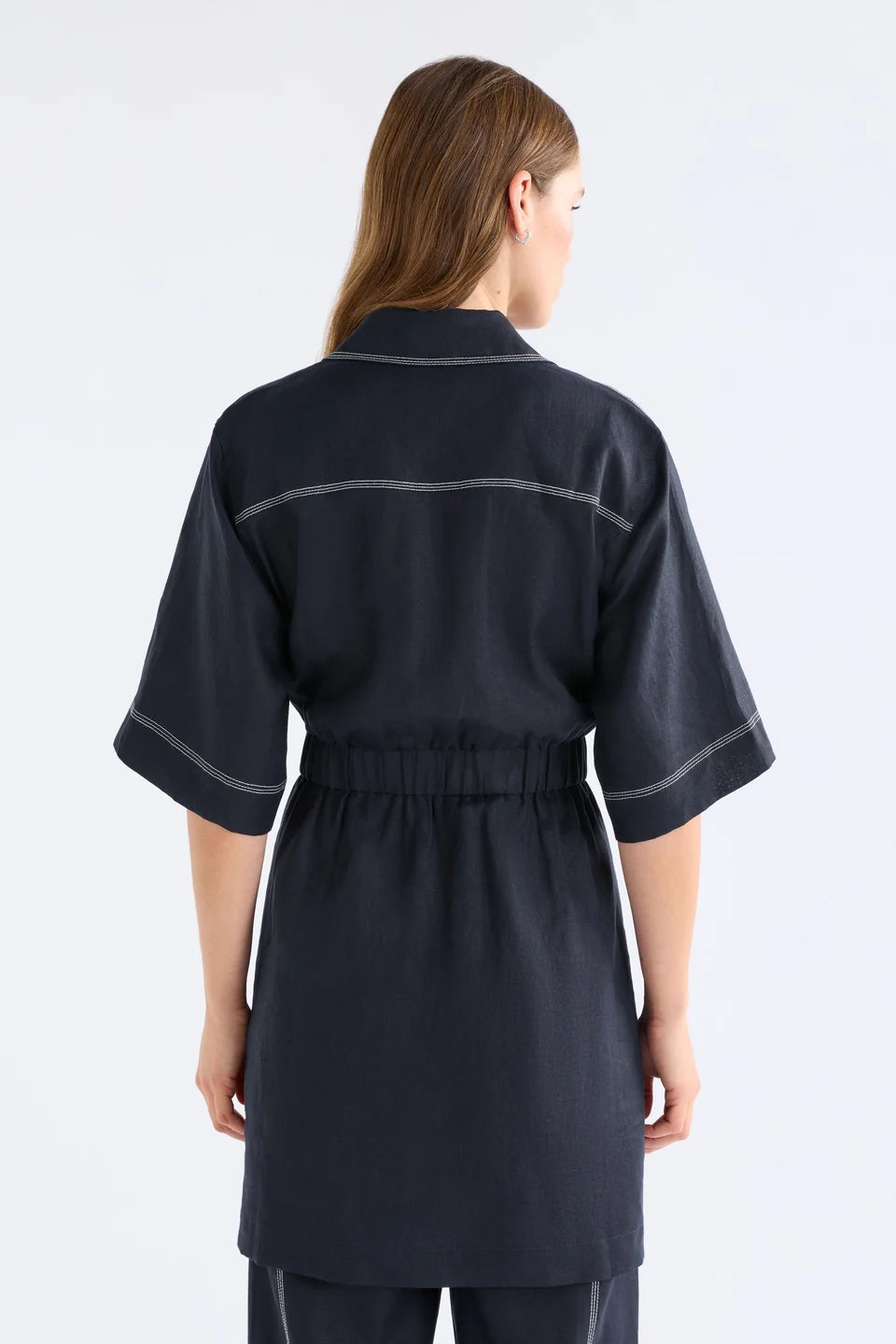 ELK SONNEN DRESS NAVY LINEN MINI BUTTON UP SHIRT DRESS WITH WHITE CONTRAST STITCHING, ELASTIC WAIST ALONG THE BACK AND TIE AT THE WAIST ON THE FRONT PLUS TWO FRONT CHEST POCKETS 