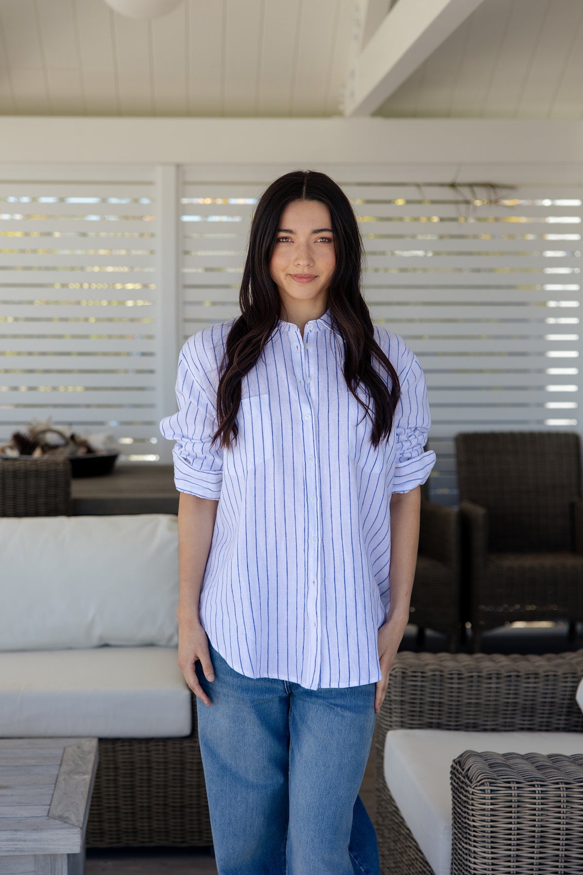 Womens white and blue vertically striped button-down shirt with pockets on the bust