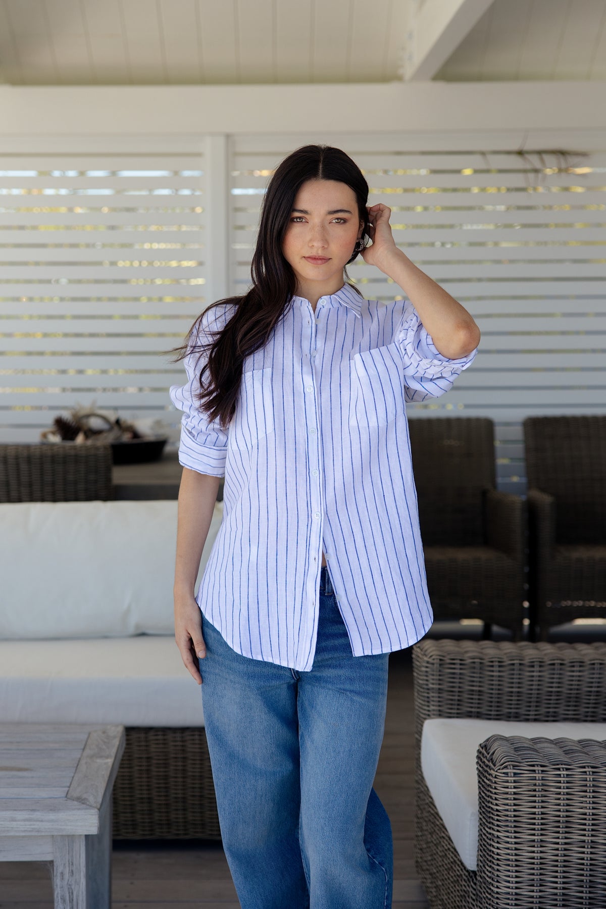 Womens white and blue vertically striped button-down shirt with pockets on the bust