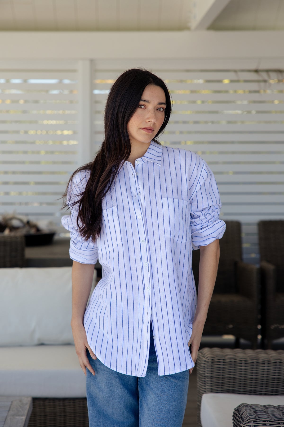 Womens white and blue vertically striped button-down shirt with pockets on the bust