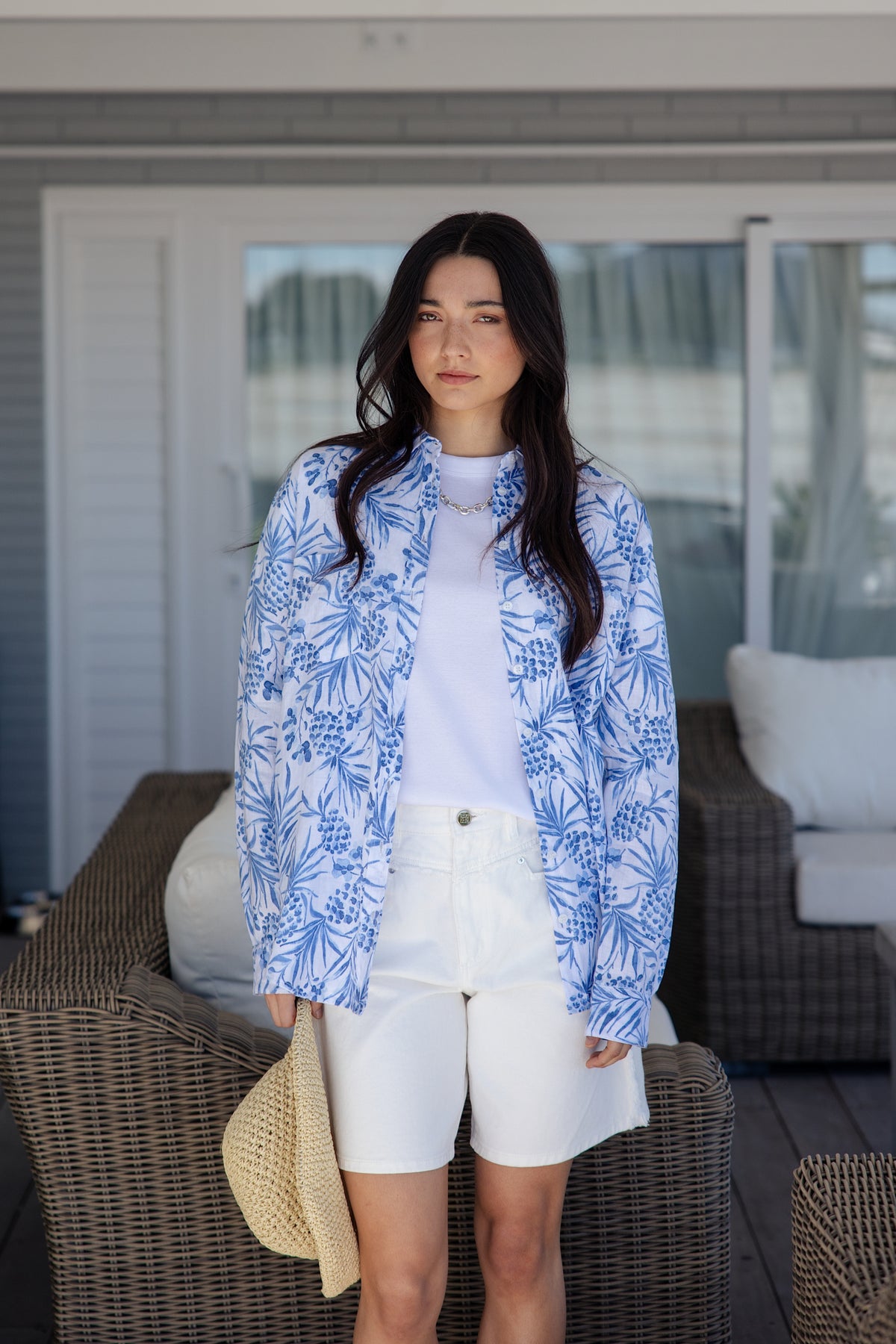 white and blue short-sleeve button-up shirt with a blue tropical print.