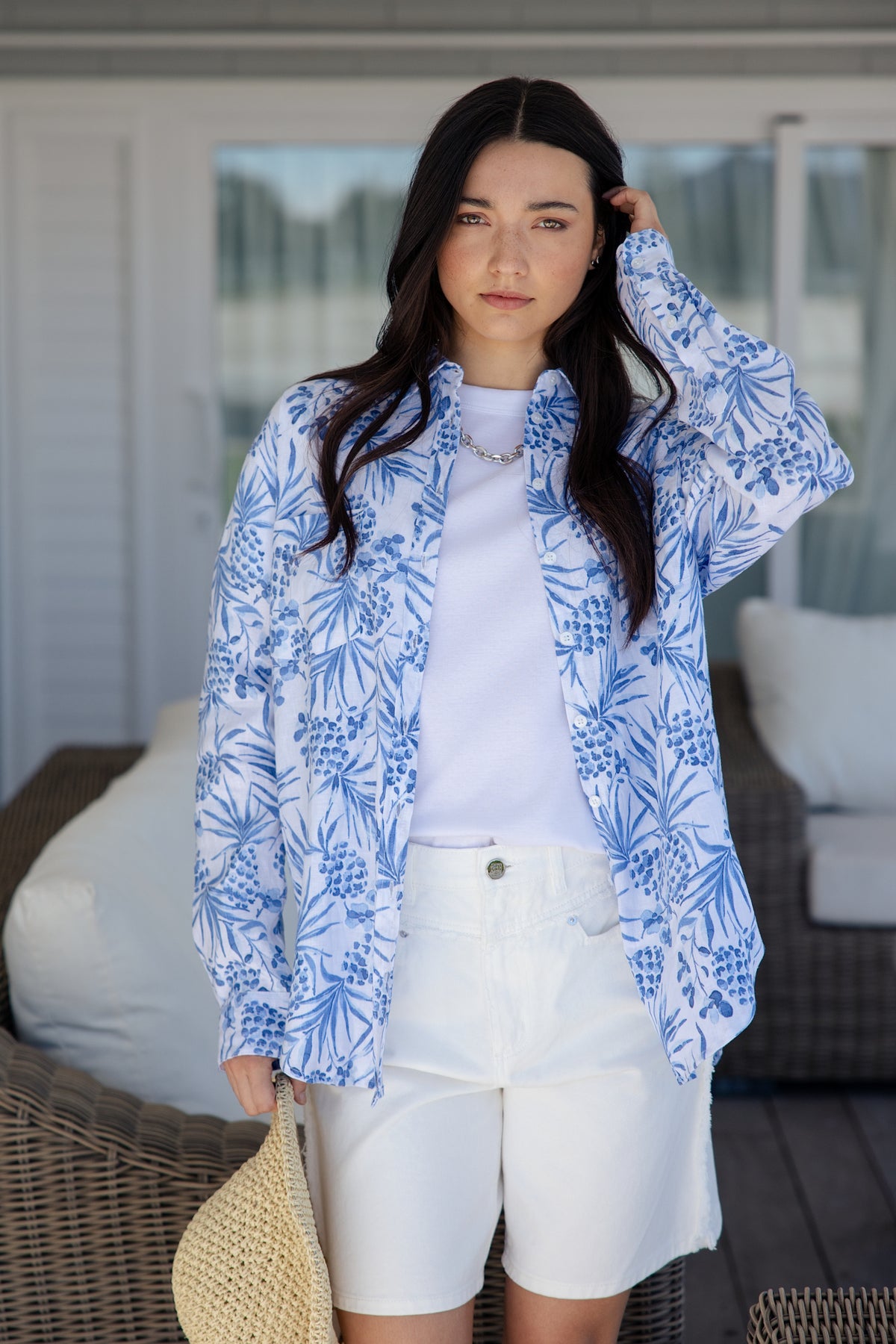 white and blue short-sleeve button-up shirt with a blue tropical print.