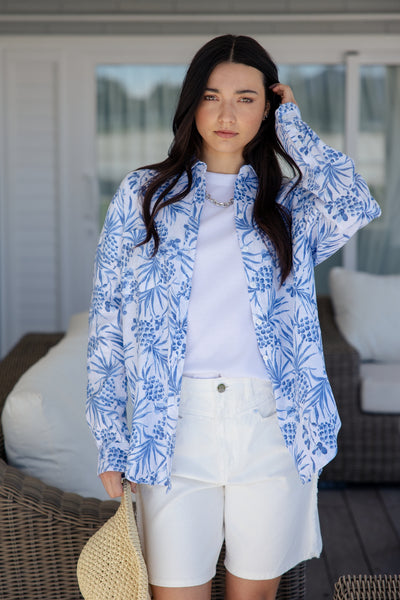 white and blue short-sleeve button-up shirt with a blue tropical print.
