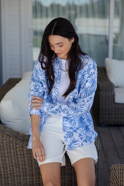 white and blue short-sleeve button-up shirt with a blue tropical print.