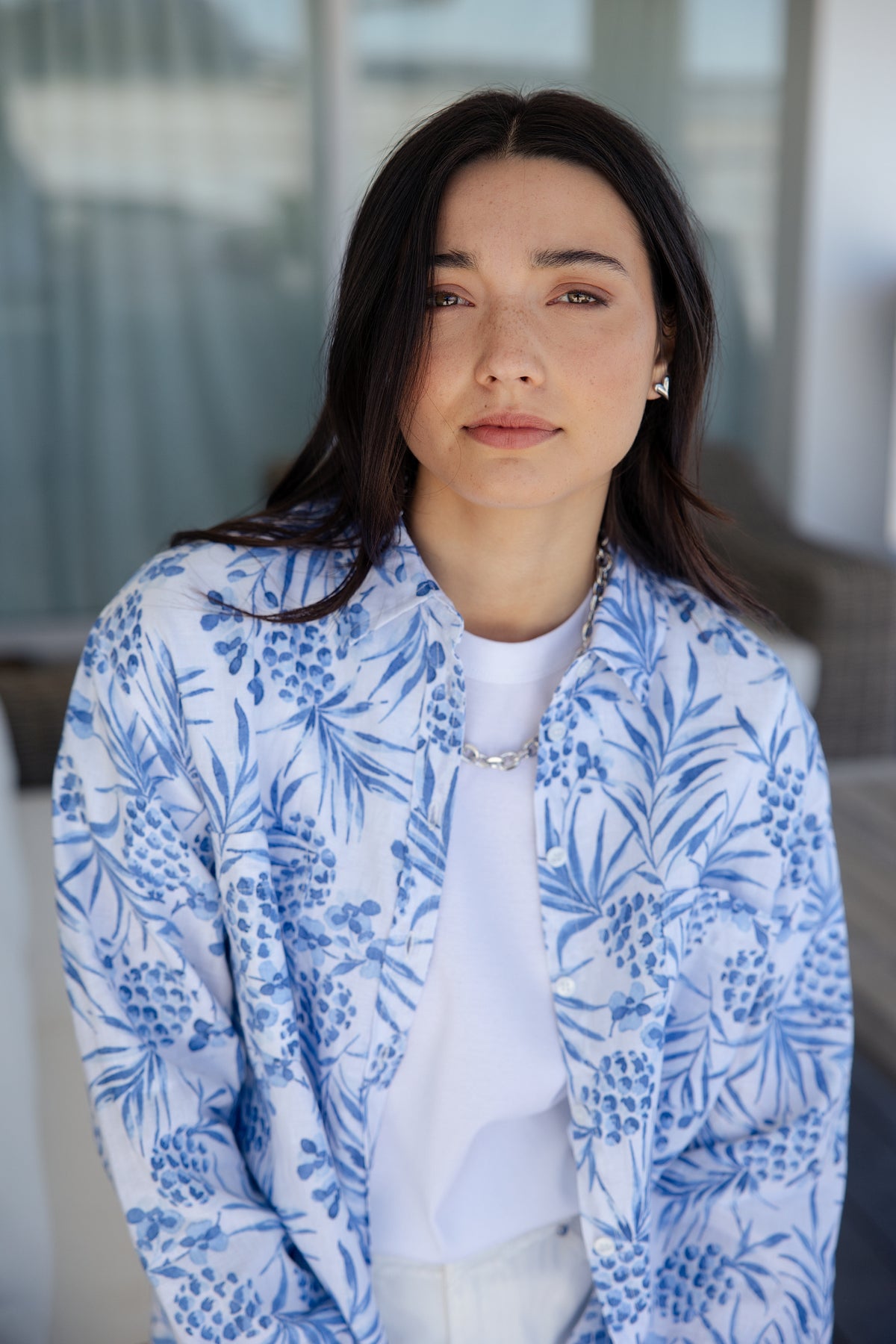 white and blue short-sleeve button-up shirt with a blue tropical print.