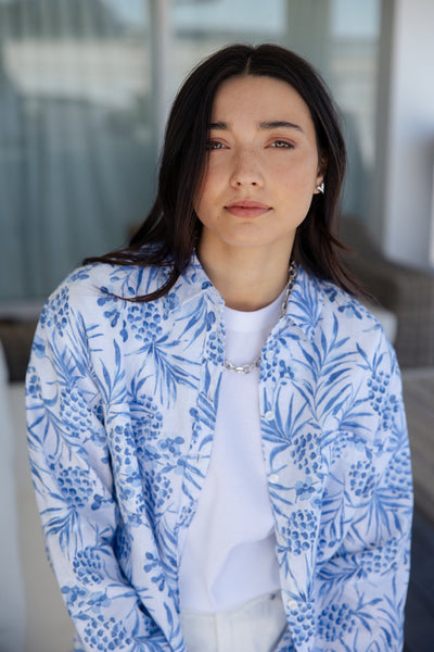 white and blue short-sleeve button-up shirt with a blue tropical print.